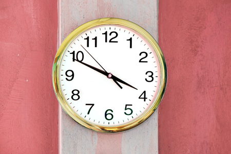 Clock hang on red wall.
