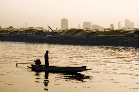 Silhouette of unknown male on the boat in the morning. Vintage Lifestyle.の写真素材