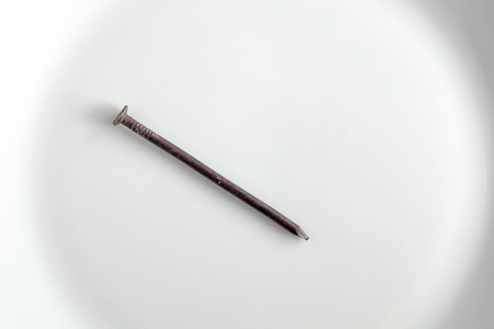 Old tack on white plate.の写真素材