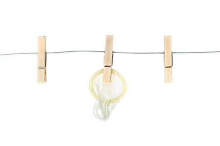 Wooden clothespin and condom on white background. Sexual concept.の写真素材