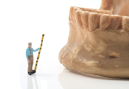 View of miniature toy work on human jaw . Health concept.