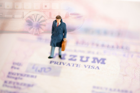 View of miniature toy, businessman walking on passport. Travel concept.の写真素材