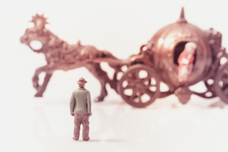 View of miniature toy, young man stand waiting girl down from horse carriage. Vintage style.の写真素材