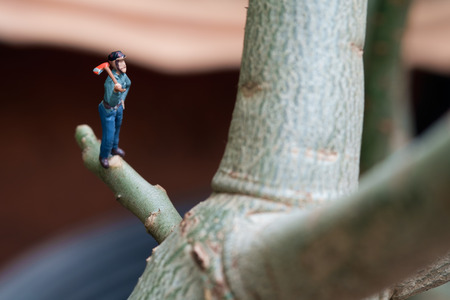 View of miniature toy, lumberman standing on tree. Focus on lumberman.の写真素材