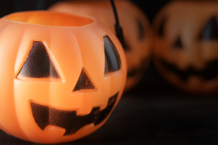 Closeup plastic toy pumpkin head on dark background. Shallow depth of field.の写真素材