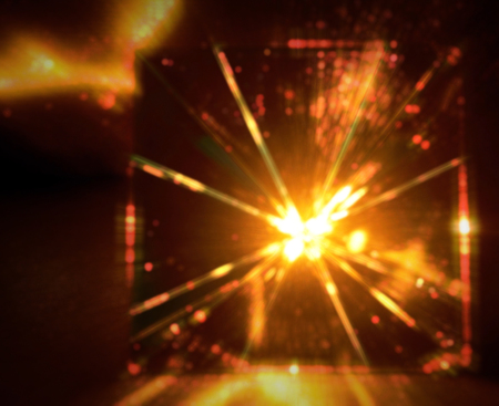Blur of light of pyramid glass on dark background. Orange tone.の写真素材