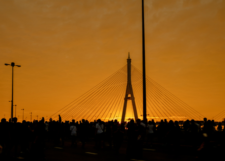 Silhouette of elevated expressway and crowd of people cross the river at twilight. Movement.の写真素材