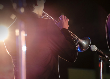 View of bugler blowing the trumpet in concert at night. Movement. Shallow depth of field.の写真素材