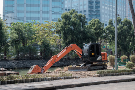 View of excavator machine in the park with sunny, building background.の写真素材