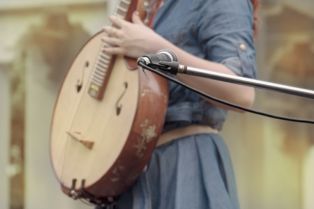 View of microphone on the stage and blur young woman playing pipa.の写真素材