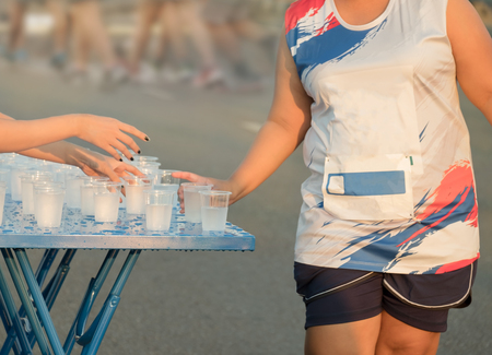 Unidentified marathon runners catching up water at Rama 8 bridge in the morning. Bangkok, Thailand.の写真素材