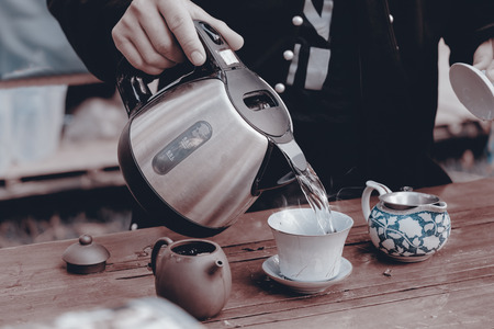 View of young man making tea in the garden. Vintage style. Movement.の写真素材