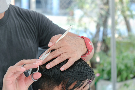 View of man hair cutting scissors in hair salon. Movement.の写真素材