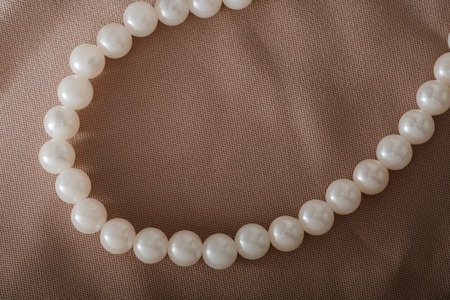 View of plastic white bead necklace on fabric.の写真素材