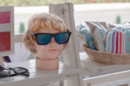 View of sunglasses with head child mannequins on shelf in the store.の写真素材