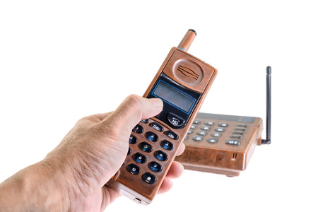 Landline phone, hand holding old telephone on white background.の写真素材