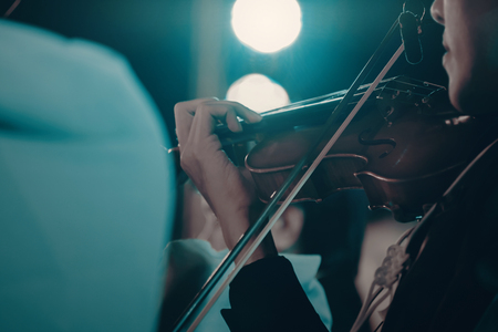 View of musician playing the violin in concert at night. Movement. Soft focus.の写真素材