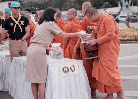 BANGKOK, THAILAND - DECEMBER 05: View of people give alms to Buddhist monk. Traditions of Merit, Father's Day, Royal palace of Ananta Samakhom on December 05,2017 in Bangkok, Thailand.のeditorial素材