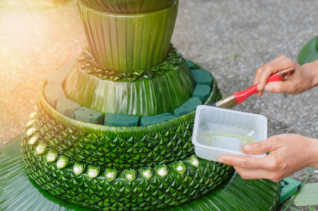 View of hands oiled on artificial sculpture of banana leaf, beautiful decoration prepare for festival. Movement.の写真素材