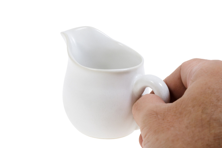 View of human hand holding ceramic jug. on white background.の写真素材