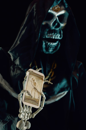 View of grim reaper show tarot card on dark background. Grim Reaper, The Death. Shallow depth of field.の写真素材