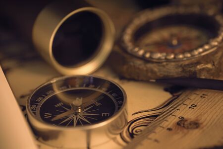 View of compass on old map. Retro style. Dark tone. Soft focus.の写真素材
