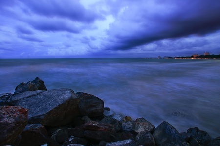 Seascape with huge storm clouds over shore.