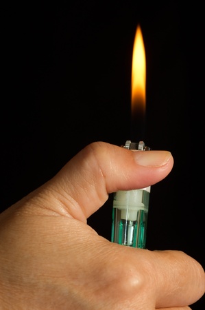 lighter in hand isolated on a blackの写真素材