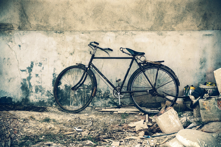 Old bicycle parked near the concrete wall.の写真素材