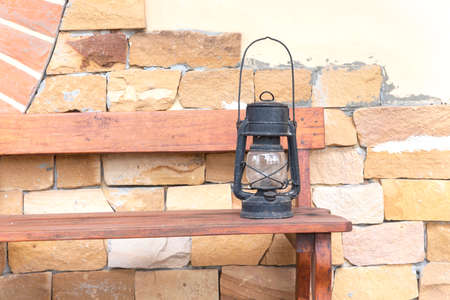 old rusty kerosene lamp on wooden benchの写真素材