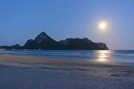 Moon rising over mountain and sea.の写真素材