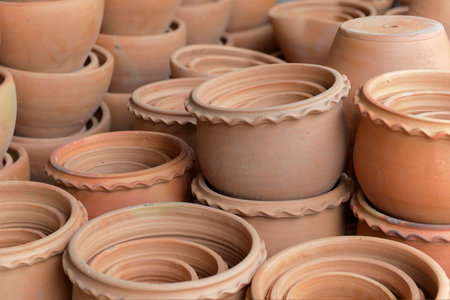 Stacks of various terracotta pots for plants for sale at a garden store.の写真素材
