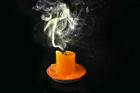 Smoke from an extinguished candle on a darkの写真素材