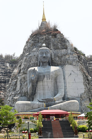 A large stone Buddha statue carved on a mountain in Thailand.の写真素材