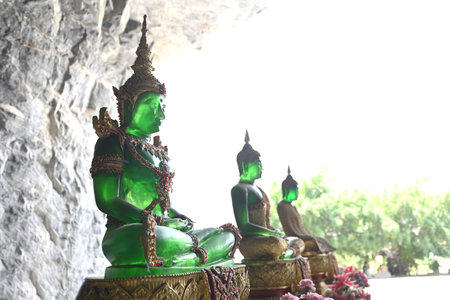 Green Buddha statue in the cave in Thailandの写真素材