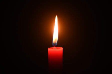 Close-up of a burning candle in a dark backgroundの写真素材