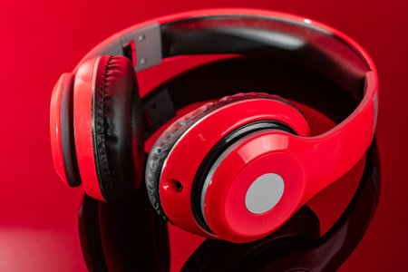 Red headphones lie on a mirrored red backgroundの写真素材