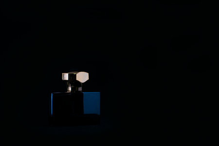 Perfume bottle with gold cap on black backgroundの写真素材