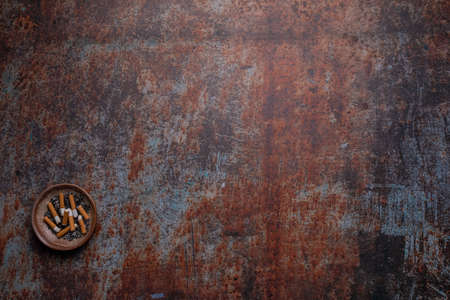 Ashtray on lower left edge on rusty background - World no Tobacco Dayの写真素材