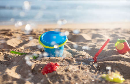 Beach toys in the sand on a sunny beach and splashing waterの写真素材