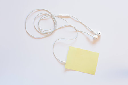 Headphones and a sticky note with blank text spaceの写真素材