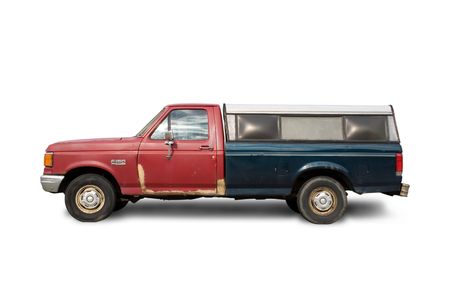 Old truck that badly needs body repairs on white backgroundの写真素材