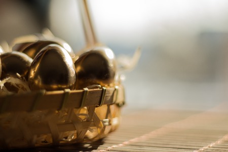 golden egg in wicker baskets, Easter backgroundの写真素材
