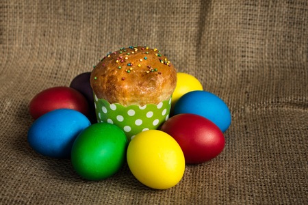 Colored Easter eggs and a festive cake, rustic backgroundの写真素材