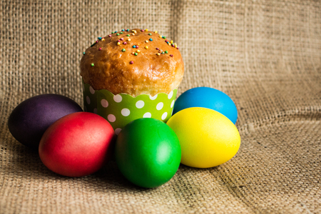 Colored Easter eggs and a festive cake, rustic backgroundの写真素材