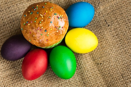 Colored Easter eggs and a festive cake, rustic backgroundの写真素材