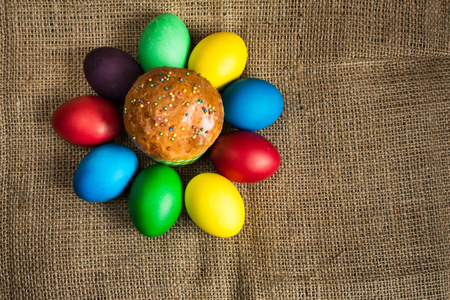 Colored Easter eggs and a festive cake, rustic backgroundの写真素材