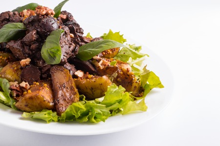 Warm salad with liver and apples on a whiteの写真素材