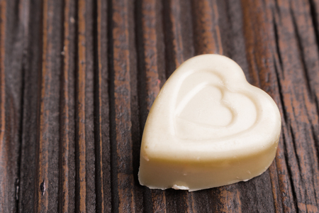 Chocolate heart-shaped candy on a wooden backgroundの写真素材