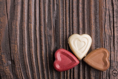 Chocolate heart-shaped candy on a wooden backgroundの写真素材